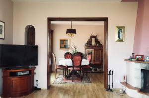 a dining room with a table and chairs and a television at Dom wypoczynkowy na Kaszubach o niezwyklym klimacie in Sierakowice