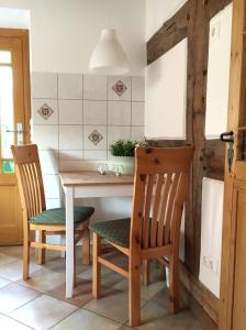 a kitchen with a wooden table and two chairs at Ferienhaus im Bauerngarten in Hoyerhagen