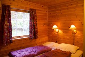 a bedroom with two beds in a log cabin at Hjelledalen Hyttesenter in Hjelle