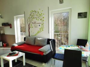 a living room with a couch and a tree on the wall at Ferienwohnungen Anne in Ravensburg