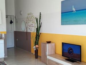 a living room with a flat screen tv and a vase at Ferienwohnungen Anne in Ravensburg