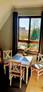 1 mesa y 2 sillas en una habitación con ventana en *To hus* Wohnung am Rande von Jever, en Jever