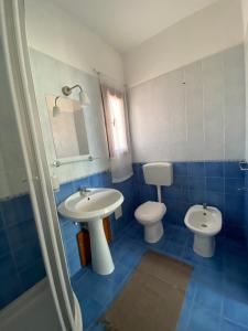 niebieska łazienka z umywalką i toaletą w obiekcie Perseo House Beach w mieście Palermo