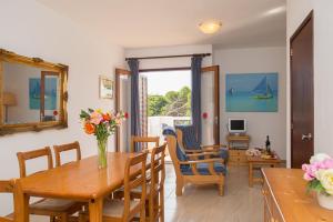 a living room with a table and chairs and a dining room at Apartamento Playa Dor 14 in Cala d´Or