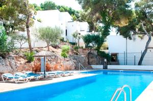 basen z leżakami i parasolem w obiekcie Apartamento Playa Dor 14 w mieście Cala d´Or