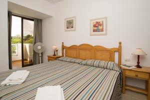 sypialnia z dużym łóżkiem i oknem w obiekcie Apartamento Playa Dor 14 w mieście Cala d´Or +7 zdjęć