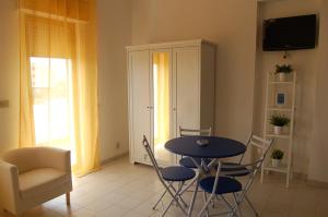 uma sala de jantar com uma mesa e cadeiras e uma televisão em Case Vacanze Farchikalà em Lampedusa