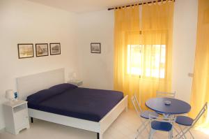 1 dormitorio con 1 cama, mesa y sillas en Case Vacanze Farchikalà en Lampedusa