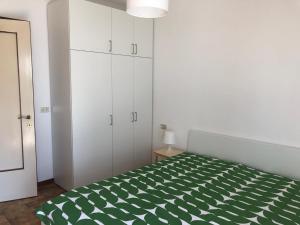 a bedroom with a green and white bed and cabinets at Villa Filiberta in Grado