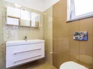 a bathroom with a white sink and a toilet at Apartment Martina in Brseč +9 photos