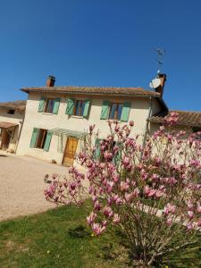 una casa con flores rosas delante de ella en Le Moulin de l'Etang, en Chaneins