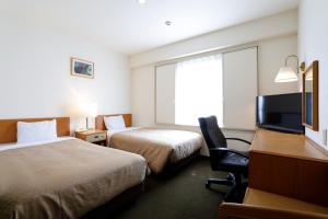 a hotel room with two beds and a desk and a television at Kawasaki Central Hotel in Kawasaki +37 photos