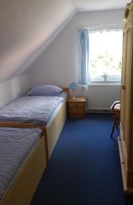 a bedroom with two beds and a window at Ferienhaus Amsel in Neuharlingersiel