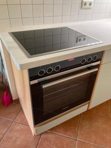 a black oven under a counter in a kitchen at Die kleine Acht - direkt am Strand in Dierhagen