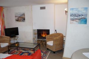 クロゾンにあるGîtes du Manoir de Goandourのリビングルーム(暖炉、椅子、テーブル付)