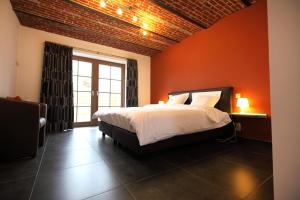 una camera da letto con un letto con una parete arancione di B&B Back2Front a Boezinge