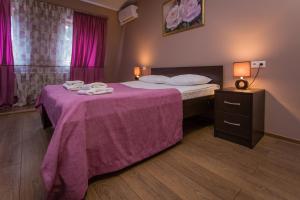 a bedroom with a bed with a purple blanket at Tsvetnoy 5 Hotel in Sochi