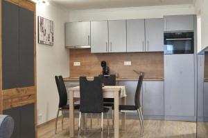 a kitchen with a table with chairs and a refrigerator at Cadet Apartments - hostAID in Siófok