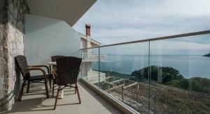 a balcony with chairs and a table and a view at Poseidon The Beach Hotel in Budva