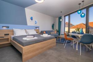 a bedroom with a bed and a dining room at Apartments Olea in Cavtat