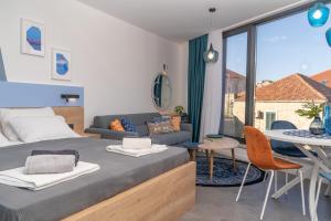 a bedroom with a bed and a couch and a table at Apartments Olea in Cavtat