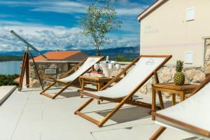 a pair of chairs and a table on a patio at Luxury Villa Allen with Pool in Klimno