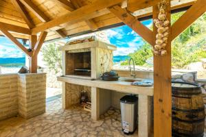 an outdoor kitchen with a stone oven and a counter at Luxury Villa Allen with Pool in Klimno