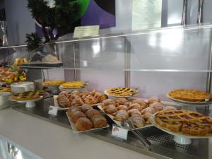 a display case in a bakery with various pastries and pies at Aurea Hotel in Tortoreto Lido