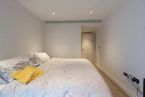 a bedroom with a bed with a yellow shirt on it at Stylish 2 Bed Flats Near US Embassy in London