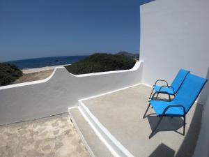 una silla azul sentada en un patio con vistas al océano en Sofia's House, en Pollonia