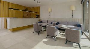 a living room with a couch and tables and chairs at Poseidon The Beach Hotel in Budva