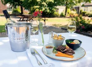 a table with a plate of food and glasses of wine at Ardboyne Hotel in Navan