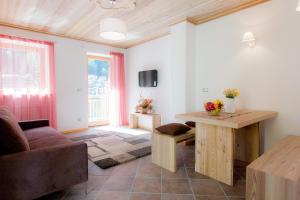 een woonkamer met een tafel en een bank bij Villa Edelweiss in Alleghe
