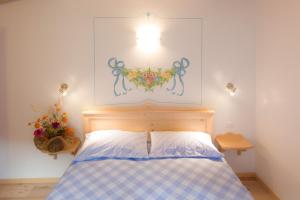 a bedroom with a bed with a blue and white checkered blanket at Villa Edelweiss in Alleghe