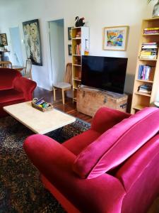 sala de estar con sofá rojo y TV en Kyogle Comfy Homestay, en Kyogle