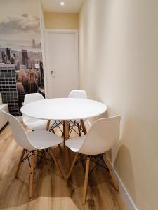 una mesa y sillas blancas en una habitación con ventana en Apartamento Costa II- Parking exterior privado incluido en Zumaia