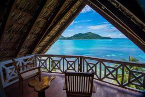 una camera con due sedie e vista sull'oceano di Colibri Hotel a Baie Sainte Anne