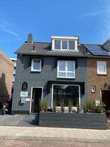 une maison noire avec des plantes devant elle dans l'établissement The Palmtree, à Zandvoort