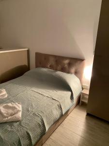 Schlafzimmer mit einem Bett mit einem Kopfteil aus Holz in der Unterkunft Studio Ra Mamaia-Nord in Mamaia Nord – Năvodari