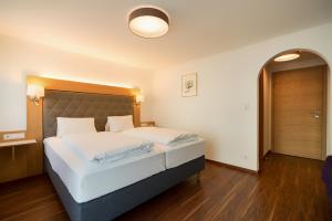 ein Schlafzimmer mit einem großen weißen Bett in einem Zimmer in der Unterkunft Hotel Cafe Lorenz in Hohenems