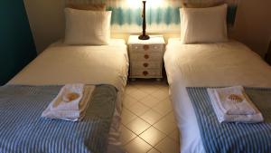 two beds sitting next to each other in a room at Vilamoura Marina Extraordinary 70 m2 T1, Marina 200m , beach 300m in Vilamoura +21 photos