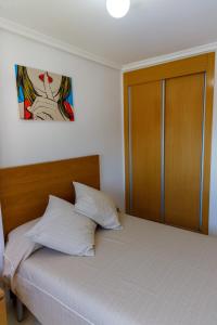 a bedroom with a bed with a wooden headboard at Mirador 33 in Peniscola