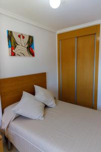 ein Schlafzimmer mit einem Bett mit einem hölzernen Kopfteil in der Unterkunft Mirador 33 in Peñíscola