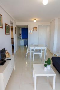 ein Wohnzimmer mit Tisch und Couch in der Unterkunft Mirador 33 in Peñíscola