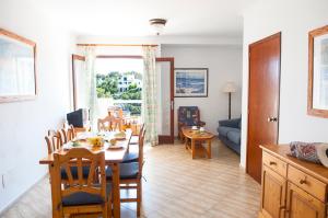 a dining room and living room with a table and chairs at Apartamento Playa Dor 17 in Cala d´Or