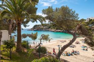 a beach with a group of people laying on the sand at Apartamento Playa Dor 17 in Cala d´Or