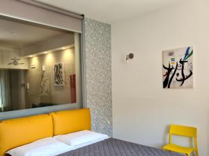 a bedroom with a yellow couch and a mirror at Casa Battisti in Agrigento