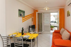 a living room with a yellow table and a couch at Apartments Pojko in Dubrovnik