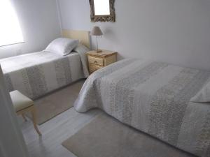 ビリャビシオサにあるPLAYA obrasのベッドルーム1室(ベッド2台、椅子、鏡付)