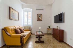 sala de estar con sofá amarillo y mesa en Casa Vintage con terrazza by Wonderful Italy, en Ostuni